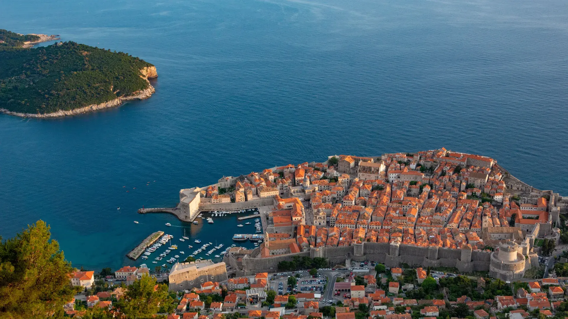 Dubrovnik's walled Old Town and harbour seen from high above, with Lokrum island offshore in the Adriatic